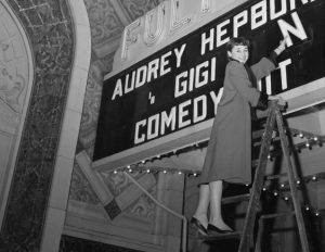 1954 --- Audrey Hepburn places her name on the top of the theater's marquee. The Belgian-born actress, who was appearing on Broadway for the first time, scored in the title role of a new version of the perrenial comedy, Gigi.. Playwright: Anita Loos. --- Image by © Bettmann/CORBIS